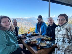 a group of people sitting around a table eating food at EVON- EcoHimal Agro-Forestry Academy in Dhulikhel