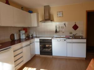 a kitchen with white cabinets and a stove top oven at Ferienwohnungen Hiemer in Lindau