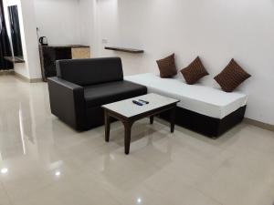 a living room with a couch and a chair and a coffee table at Sairaah Golden Suites, Shirdi in Shirdi