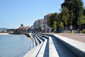 people walking on a sidewalk next to a river at Apartamento Playa Bouzas - Vigo - Parking free in Vigo