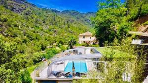 una casa en una colina con una casa de cristal en Le Massoulier Pergola, en LʼEstréchure