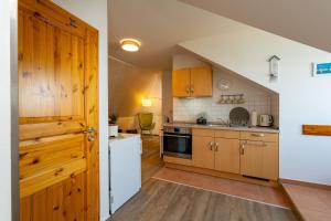 a kitchen with wooden cabinets and a white refrigerator at Ferienwohnung Haus am Seeufer in Waren