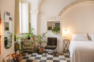 une chambre avec un lit, une chaise et des plantes en pot dans l'établissement CALMAPIANTA home for green lovers, à Putignano