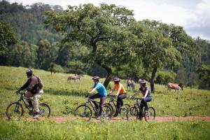 a group of people riding bikes on a dirt road at Down Gran's Self-Catering Cottage in Lobamba