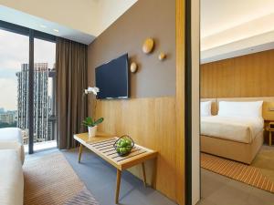 a hotel room with a bed and a table at Oasia Hotel Downtown, Singapore by Far East Hospitality in Singapore