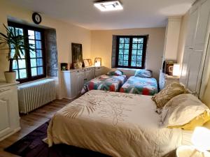 Un dormitorio con dos camas y dos ventanas. en La Fontaine du Mas, en Thiviers 33 fotos más