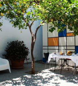 a table with chairs and a tree in a courtyard at B&B Stazione in Floridia