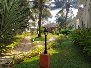 a street light in the grass next to a sidewalk at Susegad Suites Arpora Apartments & Villas with Reserved Parking in Arpora