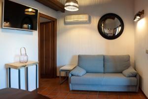 a living room with a blue couch and a mirror at Natural&Mente Apartamentos Valle del Jerte in El Torno