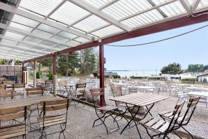 a patio with tables and chairs under a roof at First Camp Kolmården-Norrköping in Kolmården