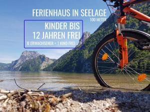 a bike parked next to a river with mountains in the background at Ferienhaus TraunseeStrand in Ebensee