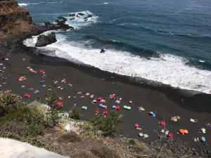a bunch of people with umbrellas on a beach at Esencia lagunera in Las Lagunas