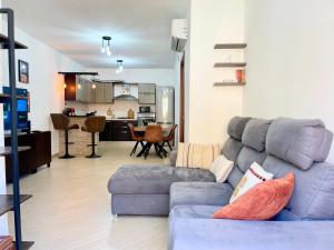 a living room with a blue couch and a kitchen at Mistral Apartment in Olmedo