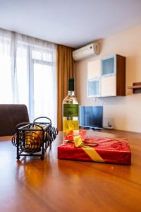 una botella de vino y un regalo rojo en una mesa en Primrose Apartment with Free Parking, en Varna