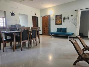 コインバトールにあるSHI's Shenba 3BHk Villa Near Ganga Hospital Coimbatoreのテーブルと椅子のあるダイニングルームとリビングルーム