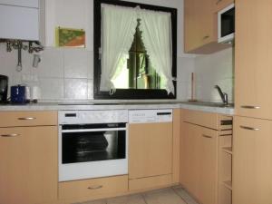 une cuisine avec un four blanc et une fenêtre dans l'établissement Ferienhaus Nr 127, Kategorie Komfort L, Feriendorf Hochbergle, Allgäu, à Karlsebene