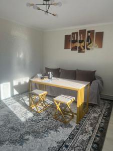 a living room with a table and two stools at Arbat Toktogul Hotel in Toktogul +37 photos