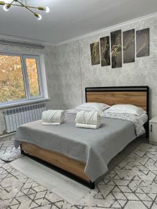 a bedroom with a large bed with two pillows at Arbat Toktogul Hotel in Toktogul