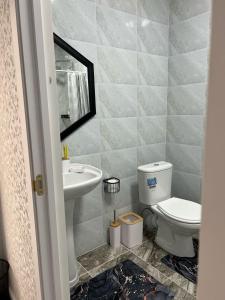 a bathroom with a toilet and a sink at Arbat Toktogul Hotel in Toktogul