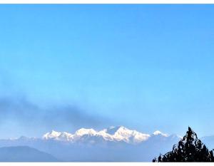 a view of snow capped mountains in the distance at Sunshraya Homestay in Darjeeling