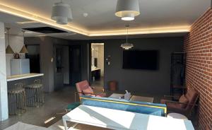 a living room with a couch and chairs and a tv at Hotel Crape Gyeongsan in Gyeongsan