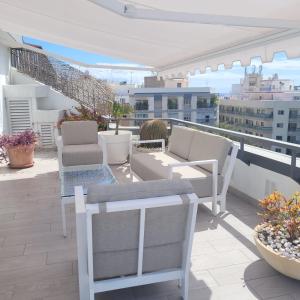 a balcony with chairs and tables on a building at Sky Santa Cruz Penthouse in Santa Cruz de Tenerife