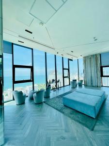 een kamer met een blauw bed in een kamer met ramen bij The base Condo 2 bedroom 1 bathroom in Pattaya