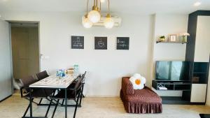 a dining room with a table and chairs and a television at The base Condo 2 bedroom 1 bathroom in Pattaya