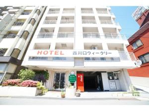 さいたま市にあるHOTEL Nishikawaguchi Weekly - Vacation STAY 43479vの目の前に看板が立つホテルの建物
