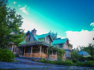 a large wooden house with a green roof at Nalagarh House by EdenHomes in Manāli