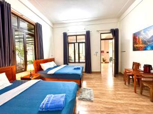 a bedroom with two beds and a table and a desk at Funny Monkeys Homestay in Phong Nha +139 photos