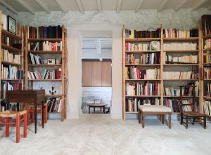 a room with several shelves of books with a table and chairs at Charme et Confort - Maison Rénovée avec Piscine - in Condillac
