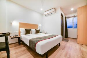 Postel nebo postele na pokoji v ubytování RG Suites Sarjapur