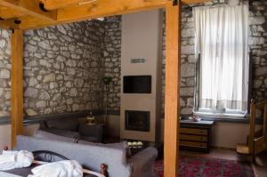 a living room with a couch and a stone wall at 1821 En Dolianis in Áno Dholianá