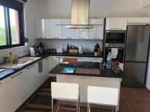 una cucina con mobili bianchi e un piano di lavoro nero di Gennadi Sunset Villa a Gennadi