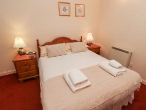 ein Schlafzimmer mit einem Bett mit zwei Handtüchern darauf in der Unterkunft Fern Cottage in Wooler + 38 Fotos