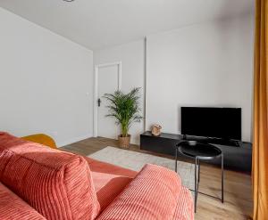 ein Wohnzimmer mit Sofa und Fernseher in der Unterkunft Saint-Louis - Cozy Apartment Close to Switzerland & Train Station in Saint-Louis