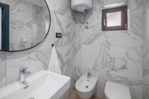 a bathroom with a sink and a toilet and a mirror at Apartments Špadići in Poreč