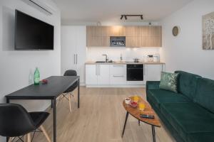a living room with a green couch and a table at Apartments Špadići in Poreč