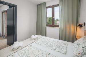 a bedroom with a bed with white towels on it at Apartments Špadići in Poreč