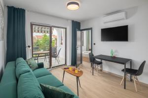 a living room with a green couch and a table at Apartments Špadići in Poreč