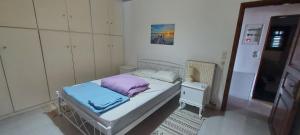 Un dormitorio pequeño con una cama y una mesita de noche. en Elena's Family House, en Artemida