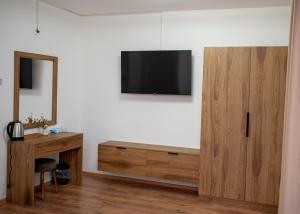 a room with a desk and a television on a wall at Apartments Rooftop Prilep in Prilep