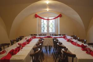 a room with a long table with red roses on it at Hotel Na Velké hospodě in Sedlice