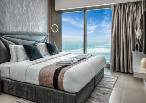 a bedroom with a large bed with a large window at Desert Key - Platinum Apartments in Gate Tower, Al Reem Island in Abu Dhabi
