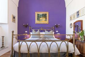 a bedroom with a purple wall and a bed at 900 - Guest House in Livorno