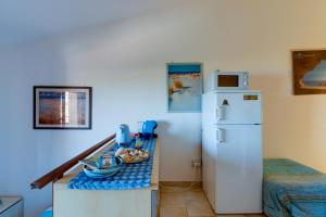 a kitchen with a small table with a refrigerator at Casa Vacanze Dune e Mare in Torre Dei Corsari +18 photos