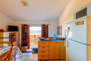 a kitchen with a white refrigerator and a table at Casa Vacanze Dune e Mare in Torre Dei Corsari