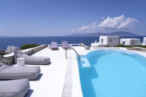 basen z leżakami nad oceanem w obiekcie Paradisiacal Villa with Pool and Sea View in Mykonos w mieście Agios Ioannis