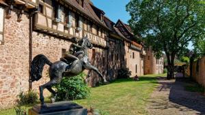 a statue of a boy falling off of a building at Remparts de Riquewihr - Le Colombier in Riquewihr